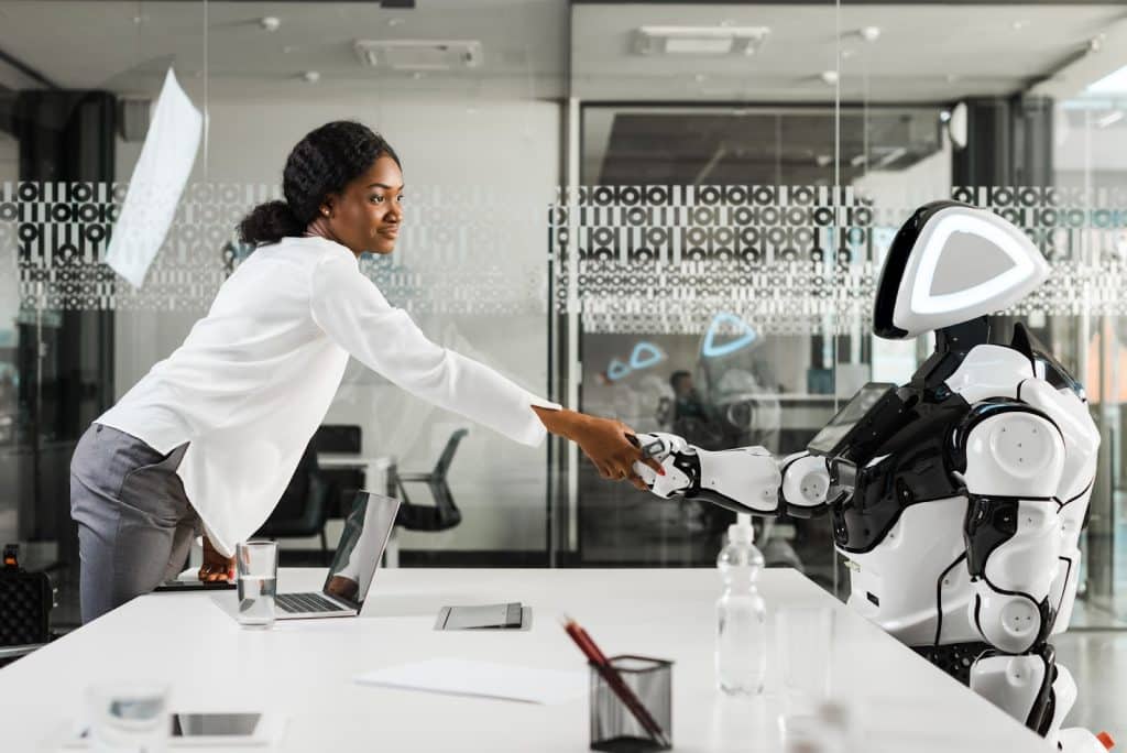 woman handing a robot something 